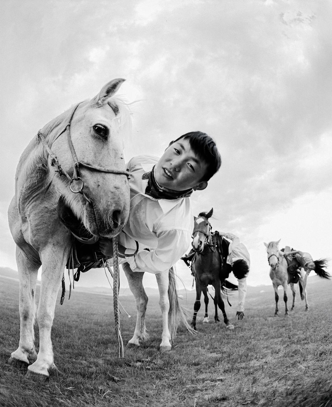 Black and white portrait of a young rider with a white horse